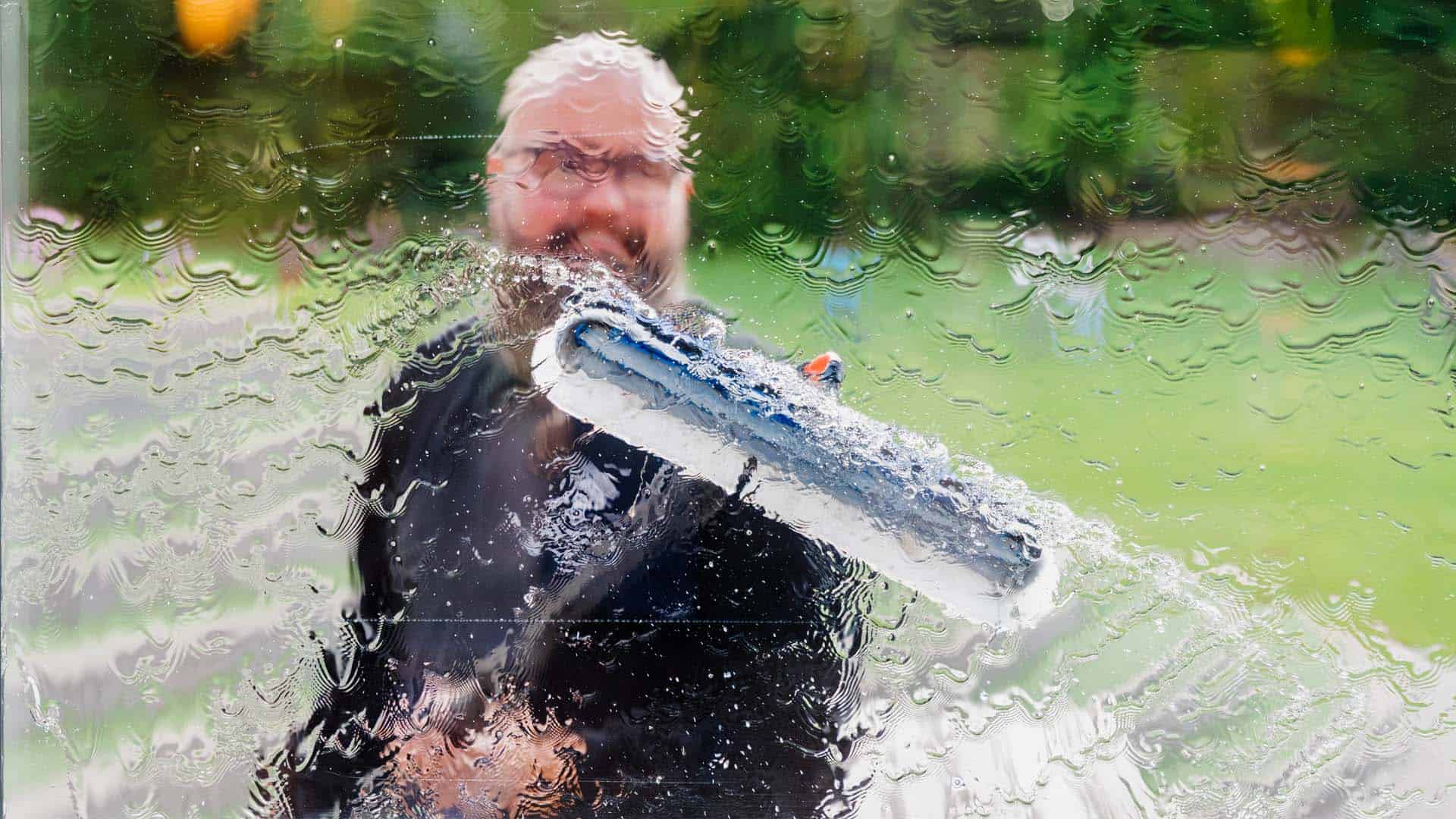 Vinduespudser fra CT vinduespolering renser ruder med vinduesskraber til private og erhverv