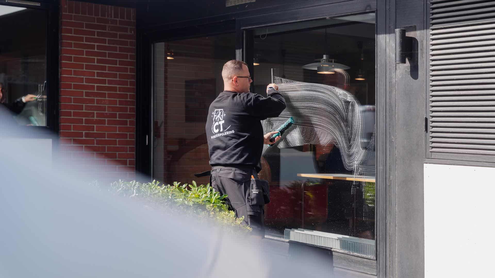 Vinduespudser fra CT vinduespolering udfører vinduespudsning til erhverv